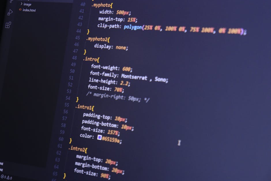 A photograph of a computer screen displaying lines of colorful CSS code for styling a webpage. The code includes properties such as 'width', 'margin-top', 'font-family', and 'font-size' with various c